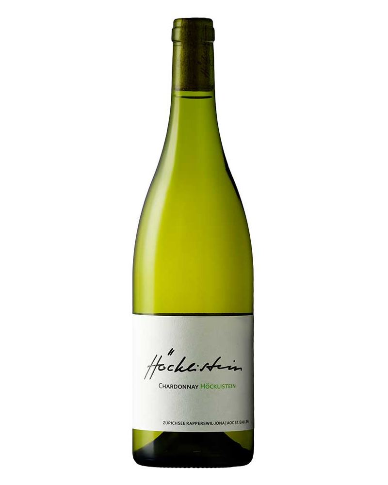 Höcklistein Chardonnay 2023 Weisswein in einer Flasche, hellgelbe Farbe, auf einem Weinglas stehender Wein.
