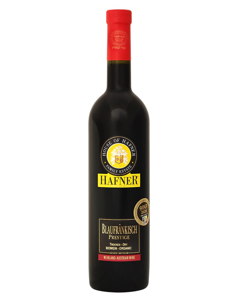Hafner Blaufränkisch Prestige 2022 Rotwein in einer eleganten Weinflasche mit Etikett, auf einem Weinglas stehender Wein.